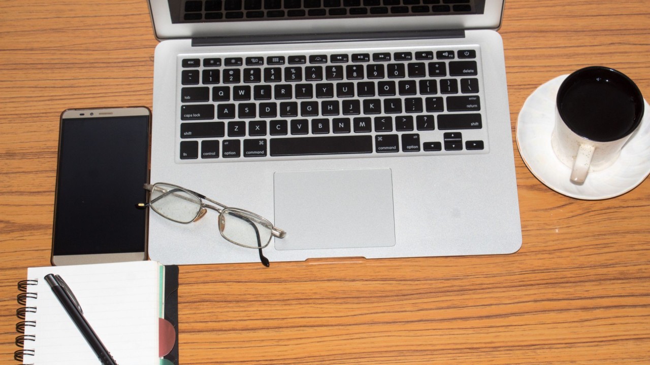 Desk with a laptop, notebook, and coffee, symbolizing productive learning